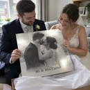 Personalised silver metal photo print, being held by a newly married couple unwrapping it