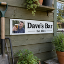 Personalised metal sign, hanging on a garden shed wall with tools and plant pots around