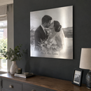 Personalised silver metal photo print, hanging on a dark painted living room wall above a console table, catching the light