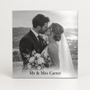 Personalised silver metal photo print printed with a black and white wedding photo of a couple kissing and the caption Mr & Mrs Carter, on a plain background