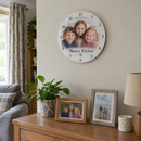 Personalised photo wall clock, hanging in a family living room above a sideboard with photos