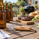 Personalised handheld wooden bottle opener at a garden barbecue