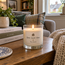 Personalised scented candle with a family name glowing in a cosy living room