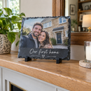 Personalised photo slate plaque with a photo and the message Our first home on a mantelpiece
