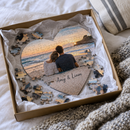 Personalised heart jigsaw: gift box with tissue paper and a part-built heart photo jigsaw of a couple at the beach with the names 'Amy & Liam'