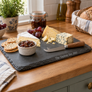 Personalised slate serving and cheese board with the name The Taylors on a kitchen worktop