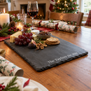 Personalised slate serving and cheese board with the name The Taylors on a Christmas table