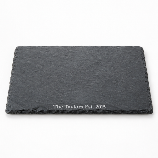 Personalised slate serving and cheese board with the name The Taylors on a white background