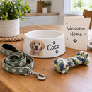 Personalised ceramic dog bowl: a new puppy welcome gift set on a kitchen table with a personalised white ceramic dog bowl printed with a puppy photo and the name 'Coco', a lead