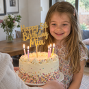 Personalised glitter cake topper on a cake with candles