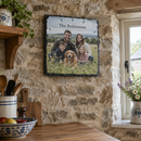 Personalised slate photo clock, hanging on an exposed stone wall in a rustic UK farmhouse kitchen