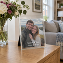 Personalised glass photo frame, on a sideboard in a bright UK living room next to a vase of flowers