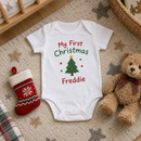 My first Christmas baby grow with the name Freddie with a stocking and teddy on a rug