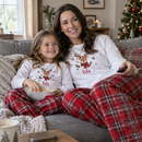 Personalised Christmas pyjamas with the name Isla worn by mum and daughter on a sofa