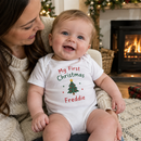 My first Christmas baby grow with the name Freddie worn by a baby held by mum