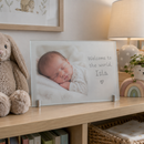 Personalised frosted glass photo frame, on a nursery shelf with soft toys and a small lamp