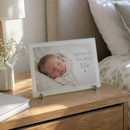 Personalised frosted glass photo frame, on a bedside table in a calm bedroom with morning light