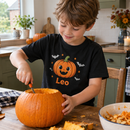 Personalised Halloween kids t-shirt with the name Leo worn while carving a pumpkin