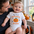 My first Halloween baby grow with the name Archie worn by a baby held by dad