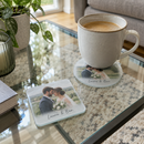 Personalised glass photo coaster, round and square versions with a cup of coffee on a modern glass coffee table