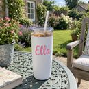 16oz white tumbler with a pink name on a garden table
