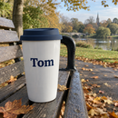 Name travel mug on a park bench in autumn