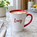 Latte mug with red inside and a name on a kitchen worktop