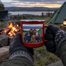 Red enamel mug with a family photo beside a campfire
