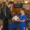 Coach presenting a personalised football with team name at an end of season awards night