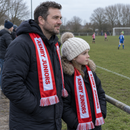 Dad and daughter on the touchline wearing a custom satin football scarf