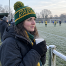 Supporter on a frosty touchline wearing a knitted team-colours bobble hat