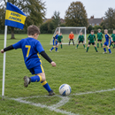 Child taking a corner kick beside a custom printed corner flag