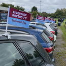 Row of cars at a club car park each flying a team car flag