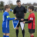 Young captains swapping a personalised team pennant before a cup match