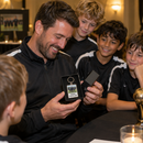 Coach opening a gift box with a personalised football coach keyring at awards night