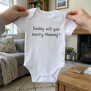 Lifestyle photo of the Daddy marry Mammy proposal baby grow in a UK home