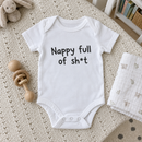 Lifestyle photo of the nappy full of sh*t funny baby grow in a UK home