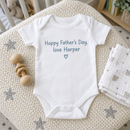 Lifestyle photo of the happy Father's Day baby grow with name in a UK home