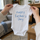 Lifestyle photo of the happy Father's Day child's writing baby grow in a UK home