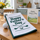Father's Day golf towel laid out as a gift with a card