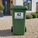 Personalised wheelie bin sticker on a green bin outside a new-build house