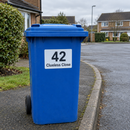 Personalised wheelie bin sticker on a blue recycling bin at the kerb