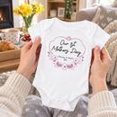 Personalised first Mother's Day baby grow lifestyle photo with Our 1st Mother's Day Flowers design in pink, printed with baby's name
