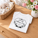 Personalised first Mother's Day baby grow lifestyle photo with Our 1st Mother's Day Flowers design in black, printed with baby's name