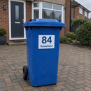Personalised wheelie bin sticker on a blue recycling bin on a driveway