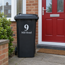 Personalised wheelie bin sticker on a black bin by a red front door