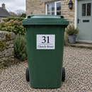 Personalised wheelie bin sticker on a green bin outside a cottage