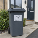Personalised wheelie bin sticker on a grey bin outside a townhouse