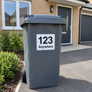 Personalised wheelie bin sticker on a grey bin outside a new-build house