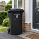Personalised wheelie bin sticker on a black bin beside a porch